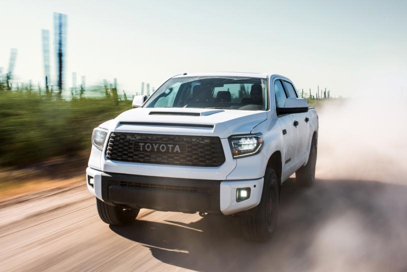 Image of a white 2019 Toyota Tundra driving on a dirt road.