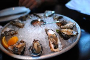 a plate of freshly shucked oysters on a bed of ice