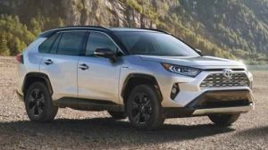 a Toyota Rav4 sitting in the sun parked on a gravel road