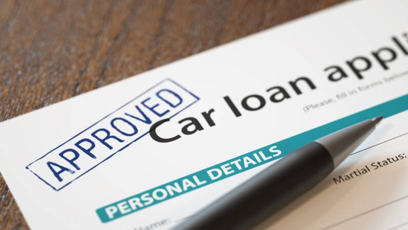 Approved car loan application form with pen