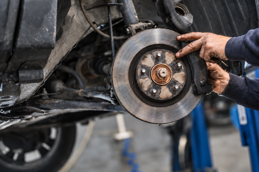 Technician inspecting brake rotor during vehicle service